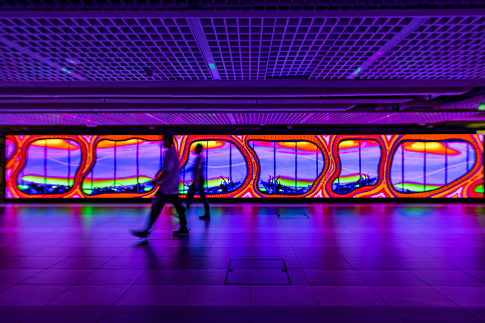 LED screen in a corridor displaying digital artwork.