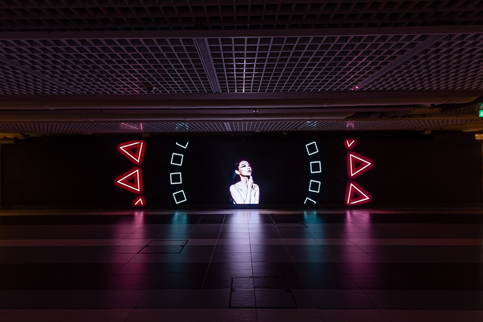 LED screen in a corridor displaying digital artwork.