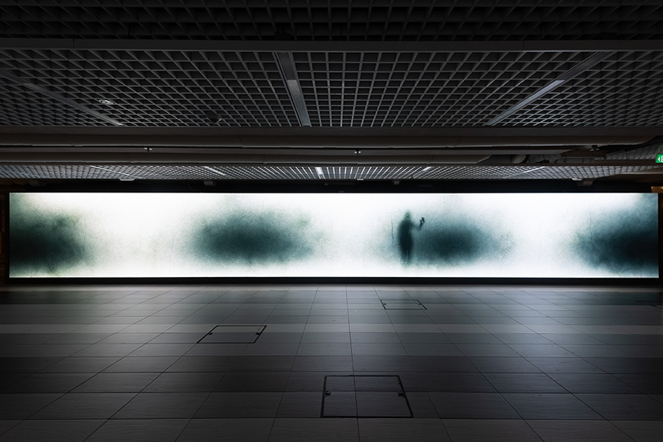 LED screen in a corridor displaying digital artwork.