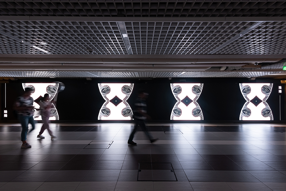 LED screen in a corridor displaying digital artwork.