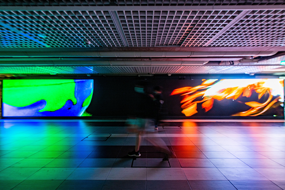 LED screen in a corridor displaying digital art.