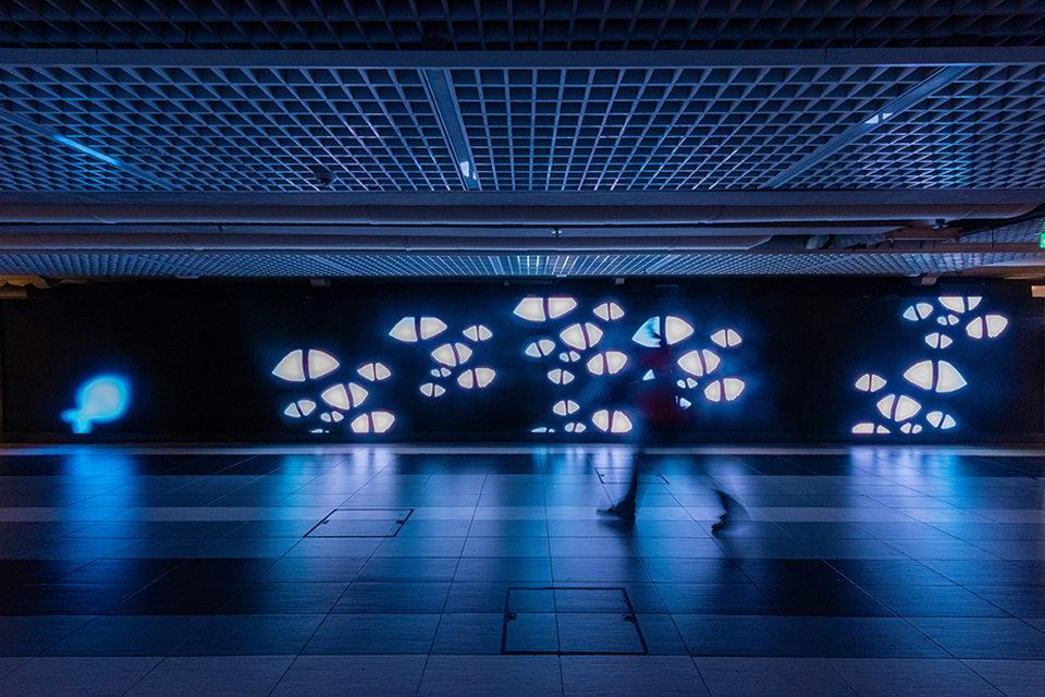 LED screen in a corridor displaying digital artwork.