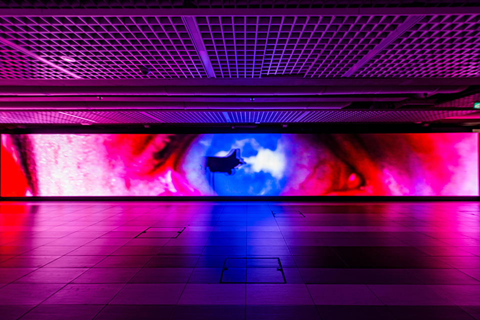 LED screen in a corridor displaying an eye