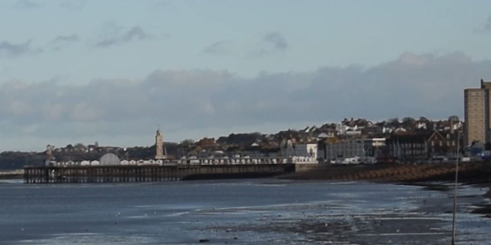 A pier with a town in the background.