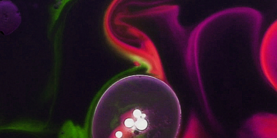 Artwork of paint in oil, purple and green swirls.